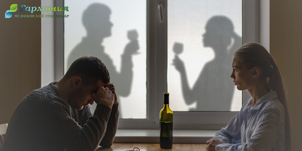 Мужчина и женщина сидят с бутылкой